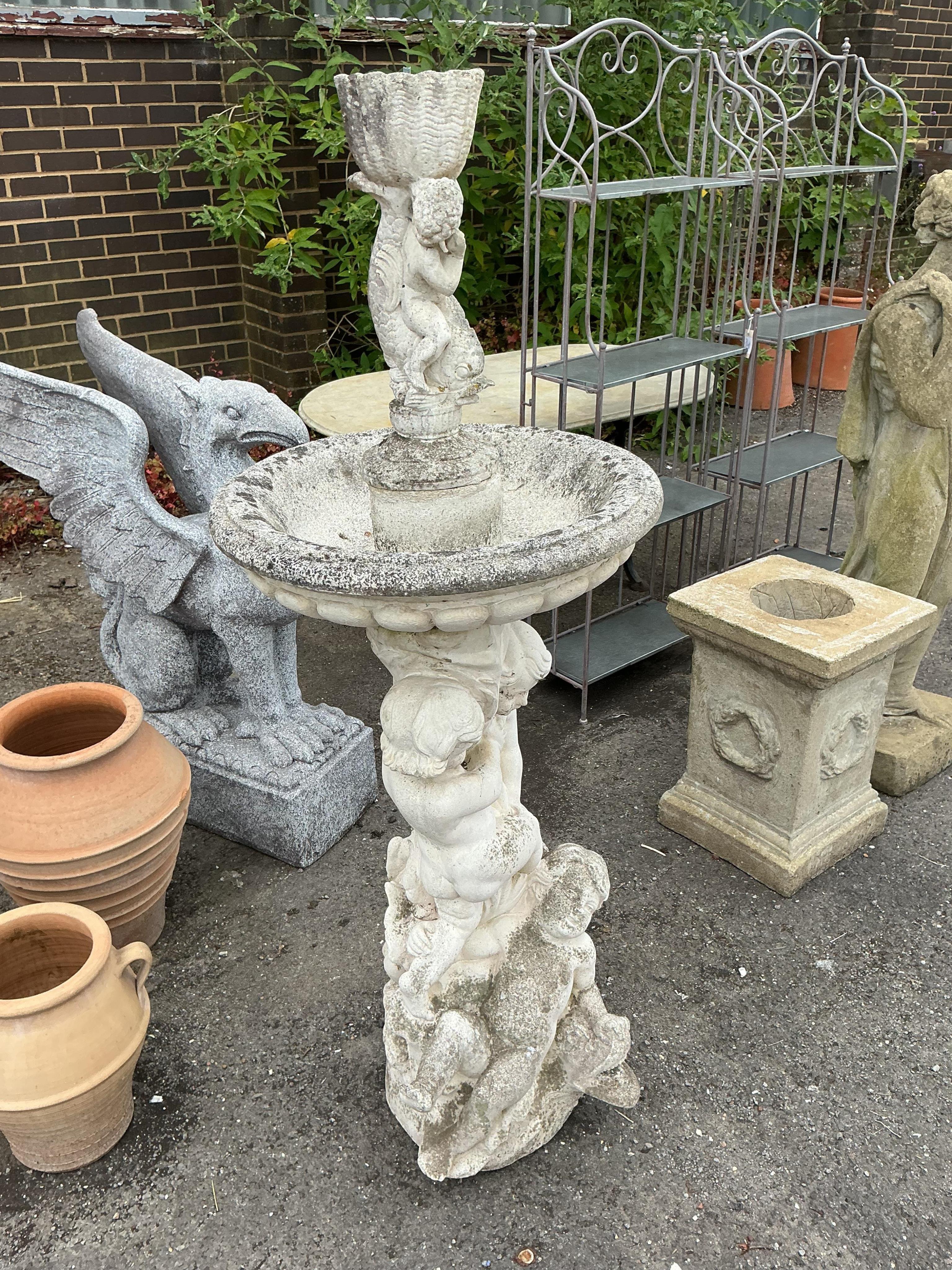 A reconstituted stone cherub and dolphin garden fountain, height 134cm